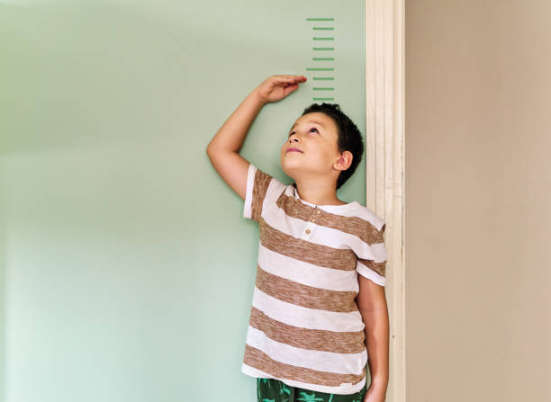 istock Child measuring his height on wall. He is growing up so fast. 1253040148
