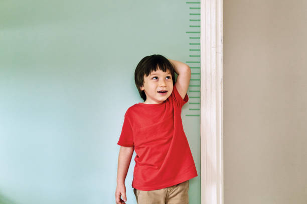 istock Child measuring his height on wall. He is growing up so fast. 1253041064