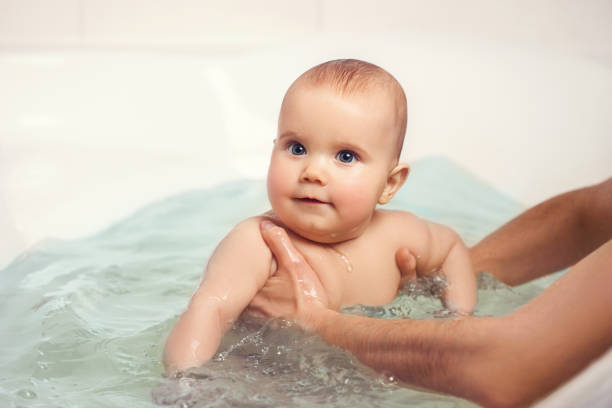 istock Hands of a careful unknown mother hold boy 1253042767