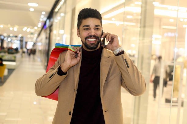 istock Man shopping and talking on phone 1253045496