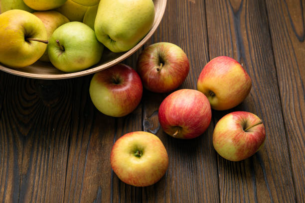 istock Green and red apples on wooden background 1253047742
