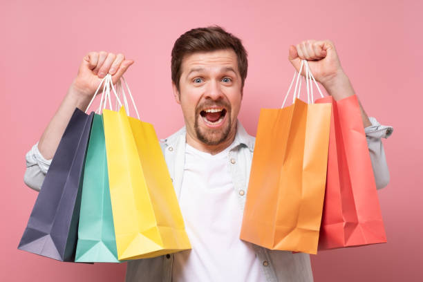istock Handsome caucasian happy postive man with shopping bags. 1253048730