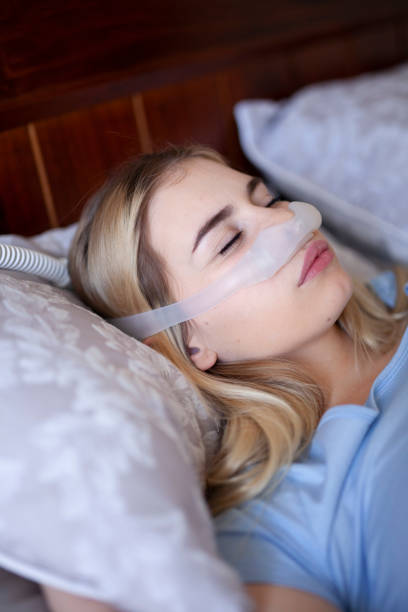 istock Sleep Apnea, Female wearing cpap oxygen machine, close up 1253052586