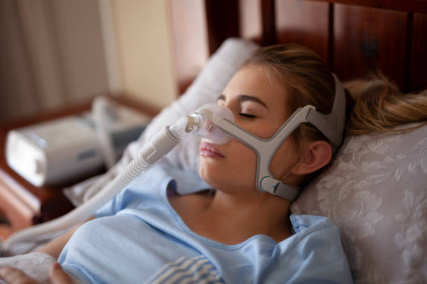 máquina cpap, mujer usando apnea del sueño durmiendo - apnea del sueño fotografías e imágenes de stock
