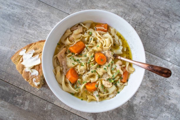 bowl of homemade chicken noodle soup with carrots stock photo