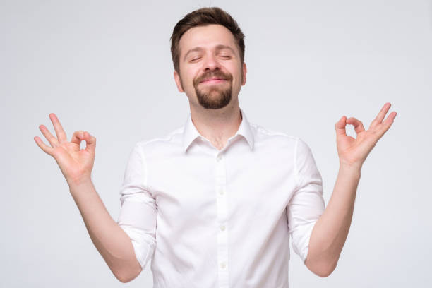 istock Handsome young man meditating with closed eyes. Stress relief techniques concept 1253053941