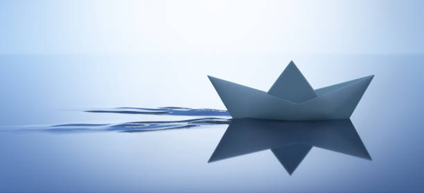 istock Paper boat on very calm water 1253055237