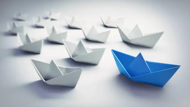 Group of white Paper Boats with blue Leader on white background