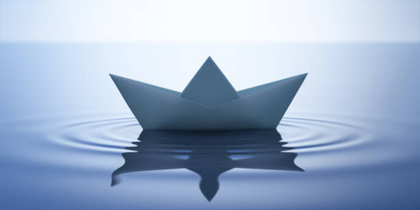 istock Paper boat on very calm water 1253055331