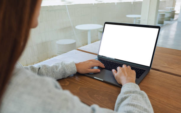 istock a woman using and typing on laptop computer keyboard with blank white desktop screen on wooden table 1253057958