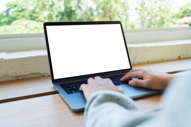 istock a woman using and typing on laptop computer keyboard with blank white desktop screen on wooden table 1253057999