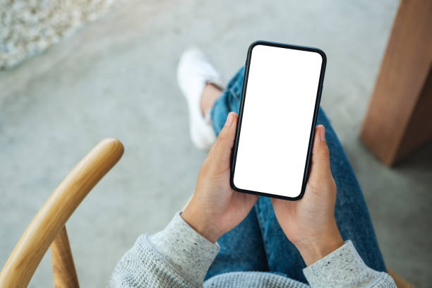istock a woman holding mobile phone with blank white desktop screen 1253058013