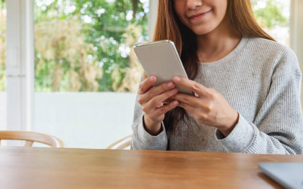 istock a beautiful asian woman holding , using and looking at smart phone 1253058015