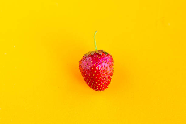 Fresh sweet strawberry on orange background, minimal concept
