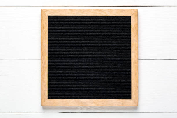 istock Empty black letterboard on white wood background. Design mockup 1253065407