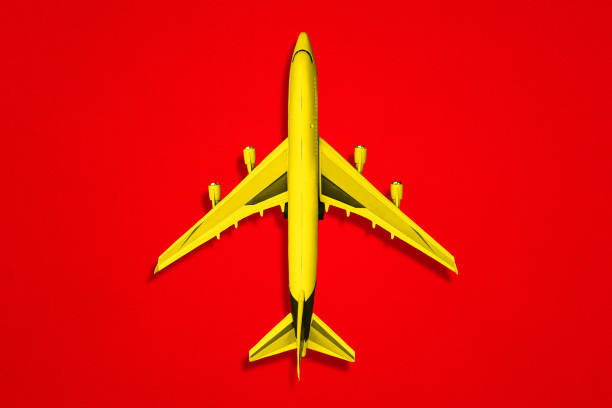 istock Yellow plane on a red background. A top view of a flat layout. 1253065591