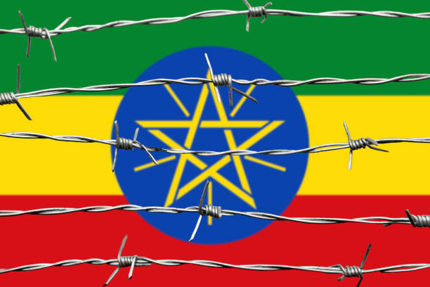 Fluttering Ethiopia flag on crimson red sky with smoke pillars background. Ethiopia problems concept.