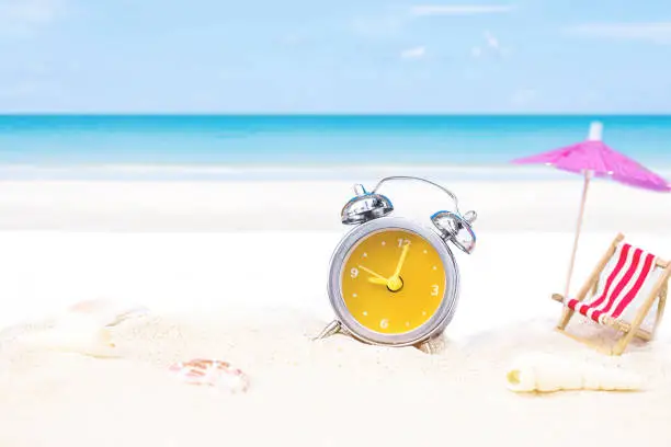 last minute to count down for travel metaphor by old retro clock on sand beach ,abstract background to time for summer vacation or travel vacation concept.