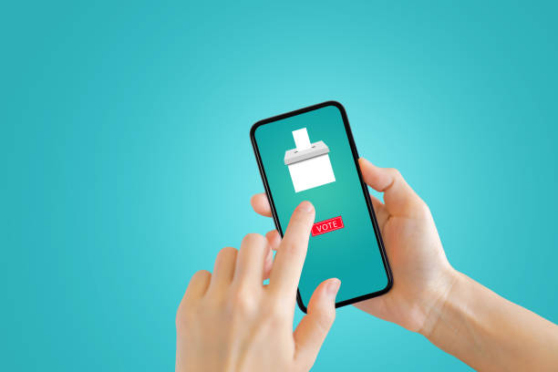 istock Hand pressing vote button for voting ballot on smartphone screen. 1253067398