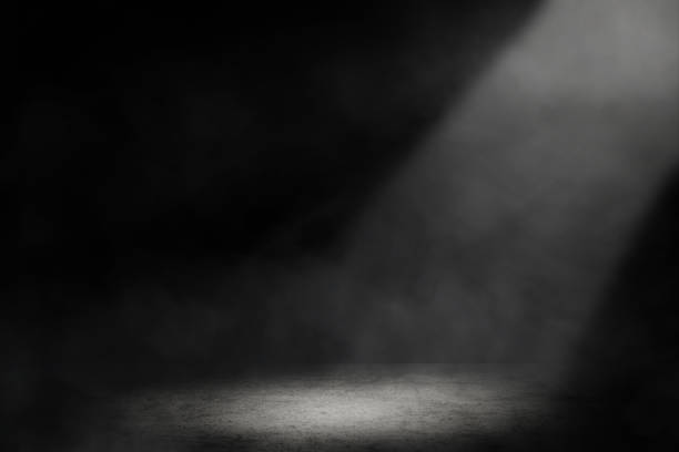 istock Studio dark room with spot lighting and fog in black background. 1253067642