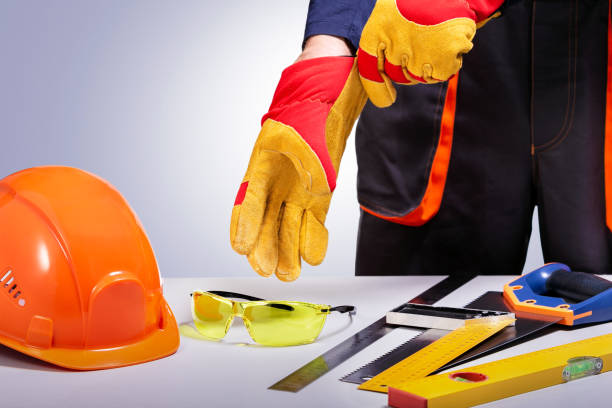 istock Construction worker putting on protective gloves. Composition with safety equipment and tools. Copy space. 1253069141