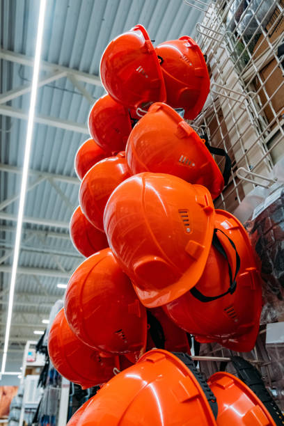 istock Stacks of orange safety construction helmets in the store 1253070774