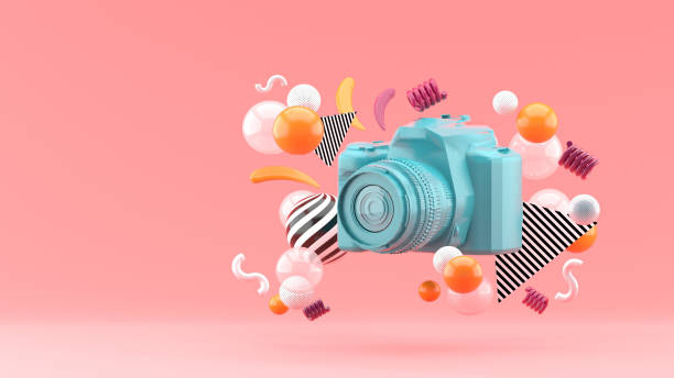 Blue camera surrounded by colorful balls on a pink background.-3d render. Blue camera surrounded by colorful balls on a pink background.-3d render. sense of science and technology stock pictures, royalty-free photos & images
