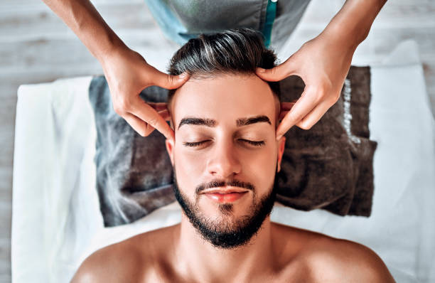 Handsome man having head massage in spa salon Handsome man having head massage in spa salon. Top view man massage stock pictures, royalty-free photos & images
