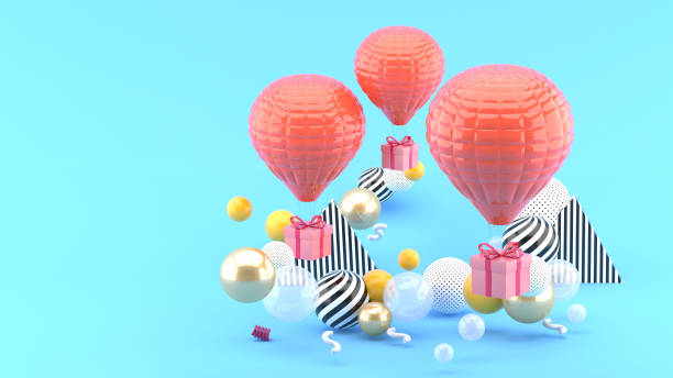 istock Pink balloon with gift box amid colorful balls on blue background.-3d render. 1253073346