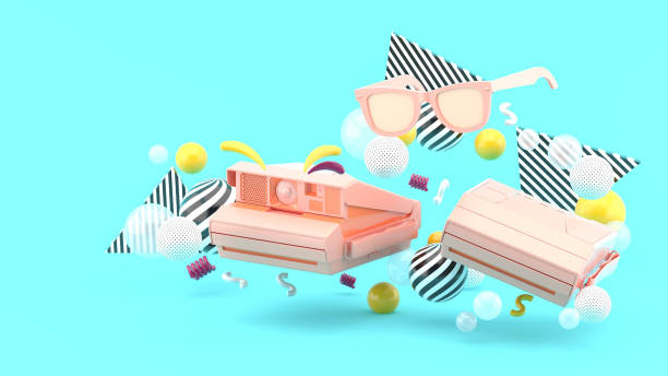 Polaroid camera and pink glasses surrounded by colorful balls on a blue background.-3d render.