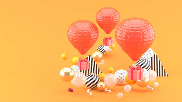 istock Pink balloon with gift box amid colorful balls on orange background.-3d render. 1253073364