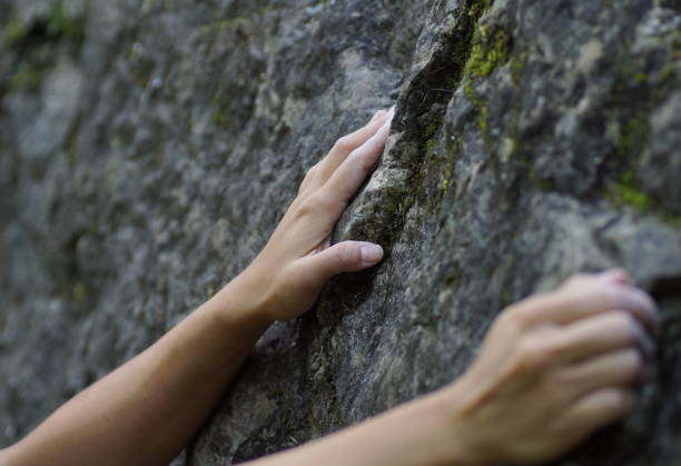 istock Girls hands grabbing a rock while climbing 1253074381