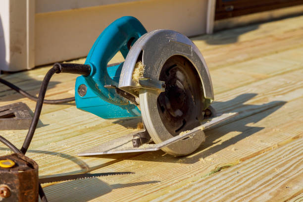 istock Carpenter cutting wooden plank hand held electric saw 1253074439