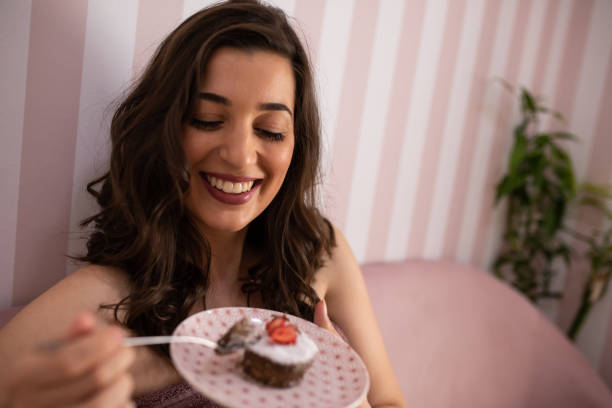 istock A beautiful woman smiling about to eat cake 1253080121