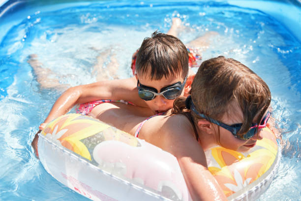 istock Backyard Water Fun Cute Little Kids Playing in Swimming Pool 1253080149