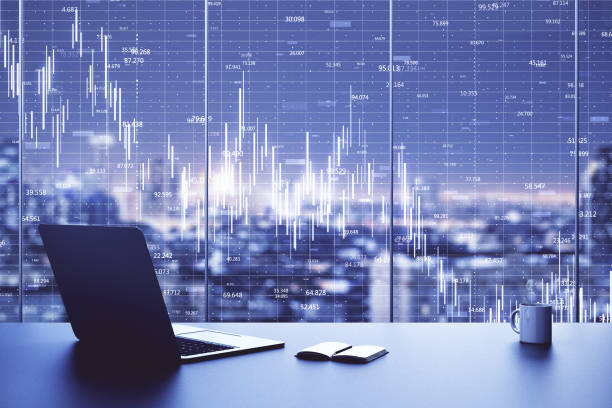 istock Laptop on table in office interior with stock market crash chart 1253082247