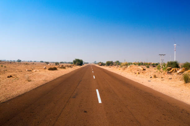route étroite d’autoroute avec le désert stérile des deux côtés tiré dans l’inde de rajasthan - thar desert photos et images de collection