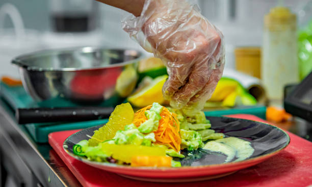 istock chef hand of cook in gloves making vegetables salad on kitchen 1253082706