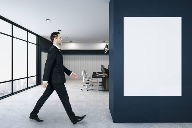 istock Businessman walking in loft coworking office interior 1253083479
