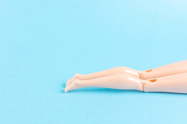 istock Creative composition with doll legs on blue background. Minimal summer vacation concept. 1253083872