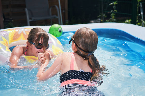 istock Backyard Water Fun Cute Little Kids Playing in Swimming Pool 1253083920