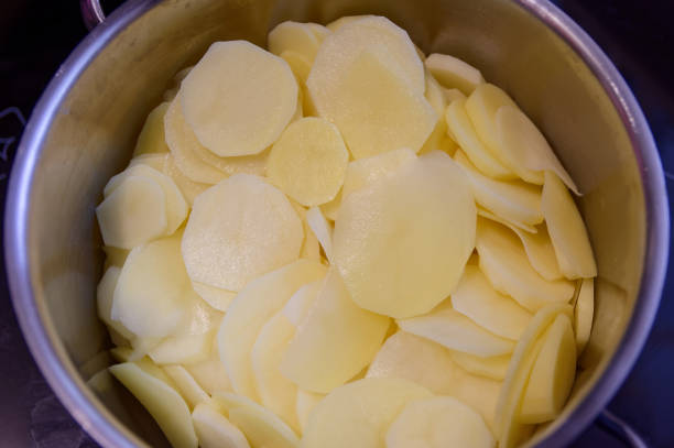 istock Thinly sliced fresh peeled potatoes in a bowl 1253084627