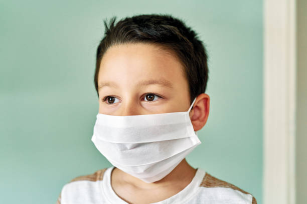 istock 6-7 years old cute child wearing surgical mask. 1253085135