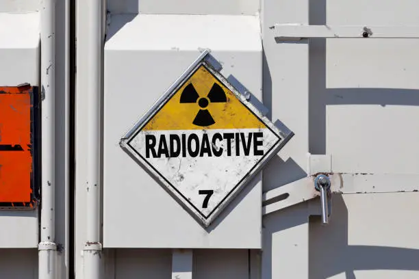 Dangerous goods sign on a truck back door. The yellow and white placard indicate that the goods transported are Radioactive substances.