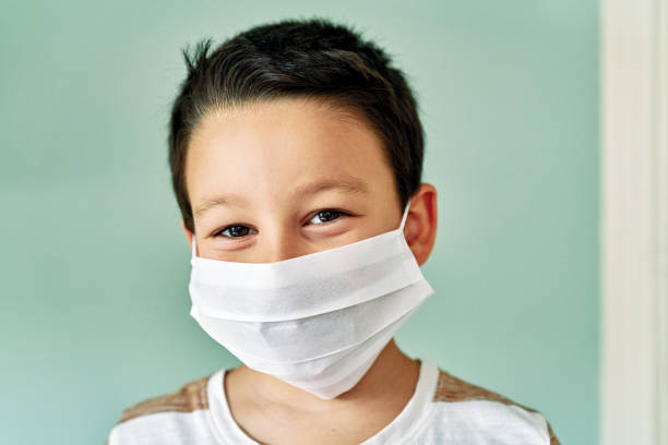 istock 6-7 years old cute child wearing surgical mask. 1253085968