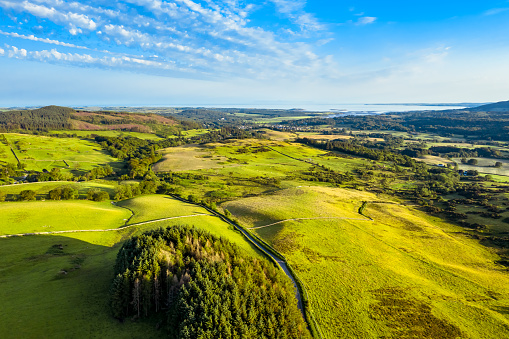 A view captured by a drone flying above the landscape of Dumfries and Galloway, south west Scotland.\nIn the distance is the Solway Firth.