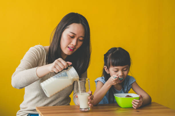 istock Happy Young Asian mother and her daughter preparing breakfast 1253087257