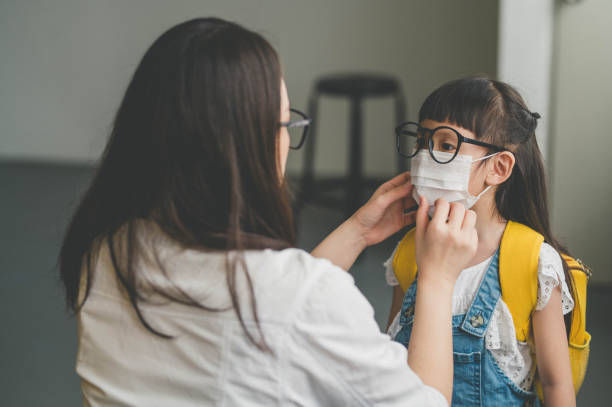istock Asian mother help her daughter wearing face mask for protection Coronavirus outbreak 1253088094