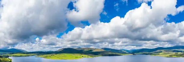 The high angle view across a loch towards a range of hills in Dumfries and Galloway, south west Scotland.
The fresh water reservoir is part of the Galloway Hydro Electric Power scheme.