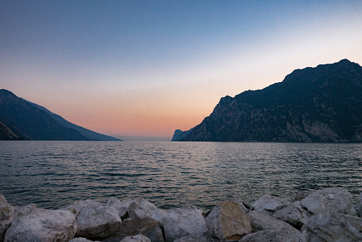 Garda Lake at sunset with orange and blue sky shot from shore – Malcesine, Lombardy, Italy